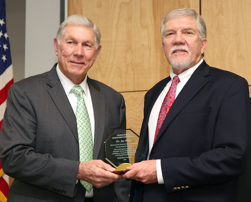 Armond Morris, chairman of the Georgia Peanut Commission, is shown (left) presenting the Distinguished Service Award to Joe West, assistant dean of the University of Georgia Tifton campus.
