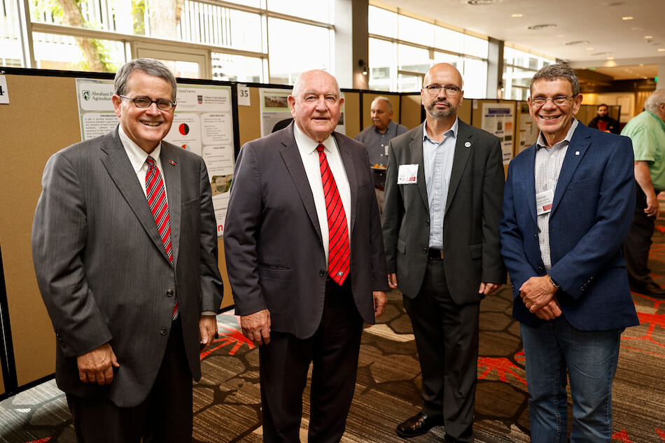 From left, UGA President Jere Morehead, University System of Georgia Chancellor Sonny Perdue, Institute for Integrative Precision Agriculture Interim Co-Director Jaime Camelio and University Professor George Vellidis attend the poster competition during the inaugural international conference. (Photo by Andrew Davis Tucker)