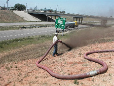 Worker applying compost to slope with pneumatic blower