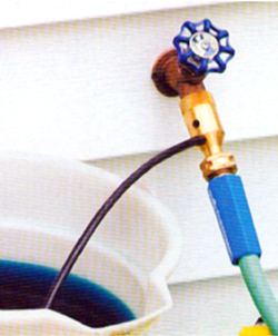 Hozon valve attached to faucet and hose with a tube going into a bucket of fertilizer stock