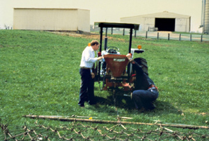 Ejemplo de siembra de césped mediante transmisión y arrastre. Arrastre de cadena unido al tractor.