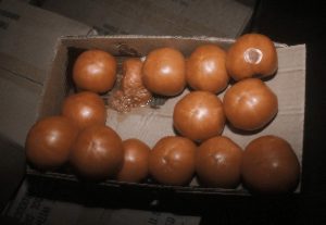 Photo showing box of soft and bruised tomatoes.