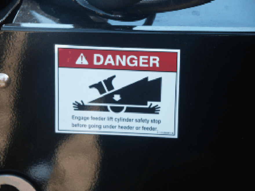 Danger label showing a person being crushed by machinery