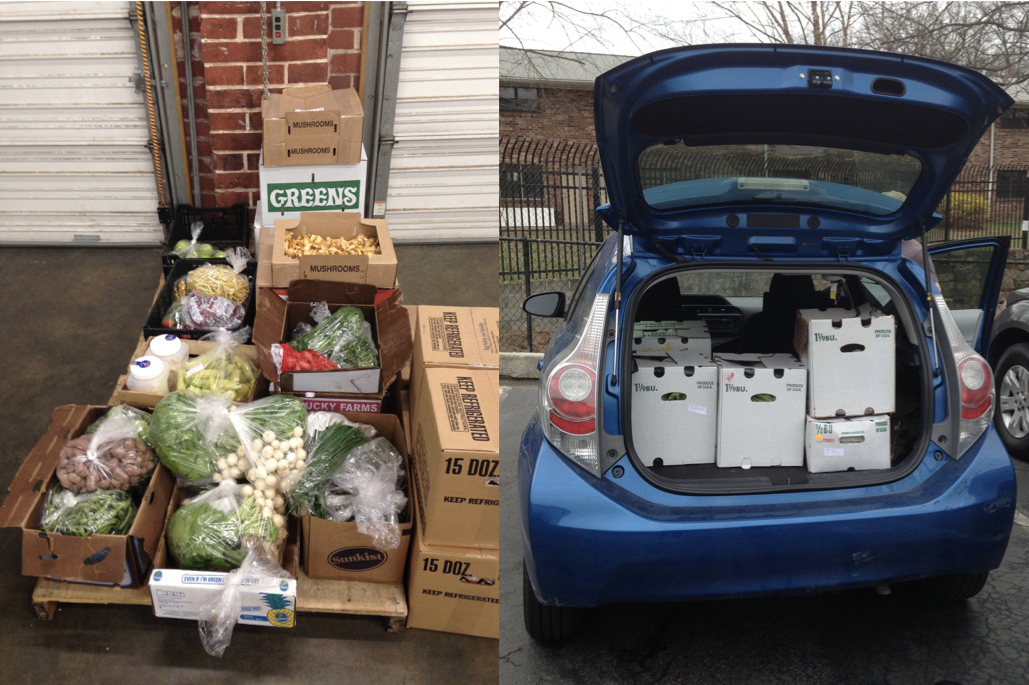 Boxes of produce on a table, and the open trunk of an SUV that is filled with boxes