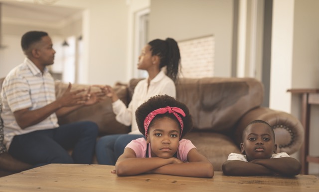 Kids with parents arguing in background