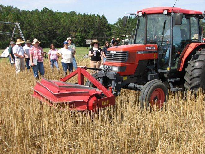 Tractor with a roller-crimper attached to the front.