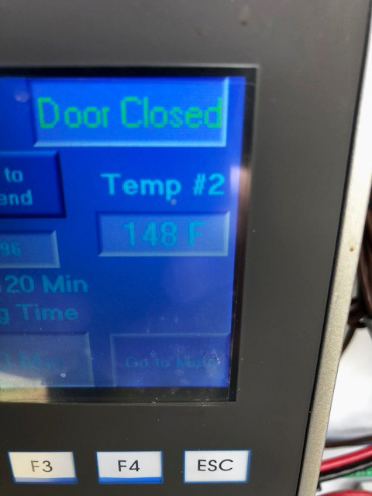 A temperature readout on the drum composter shows a temperature of 148 degrees Fahrenheit.