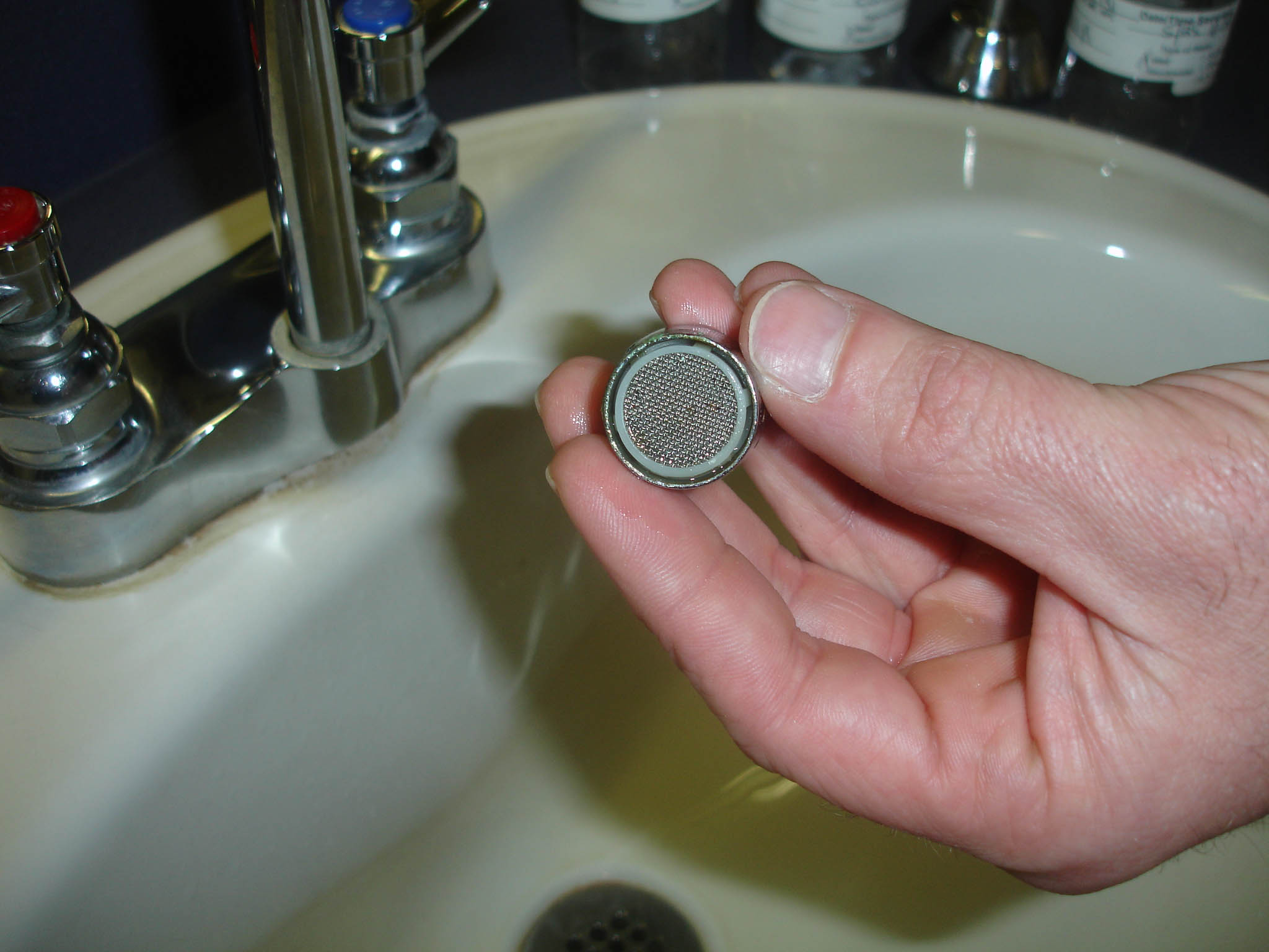 Photo showing the removal of aerator from sink faucet