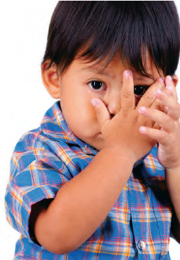 boy covering face with hands (stock photo)