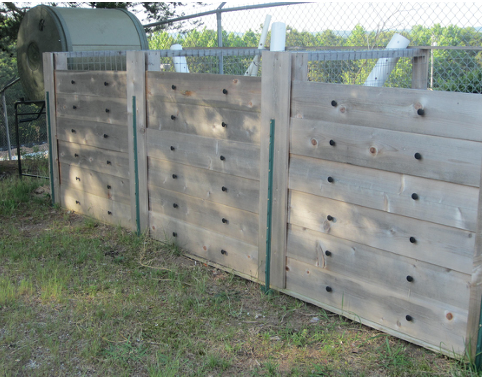 Three compost bins with wooden sides.