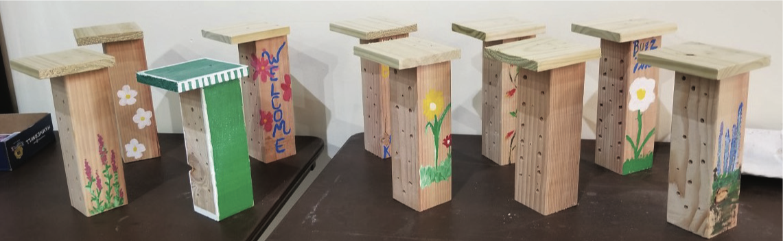 Simple “bee hotels” consisiting of a decorated block of wood with holes drilled into it