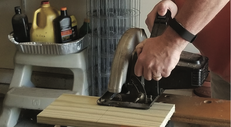 A person cutting a plank of wood