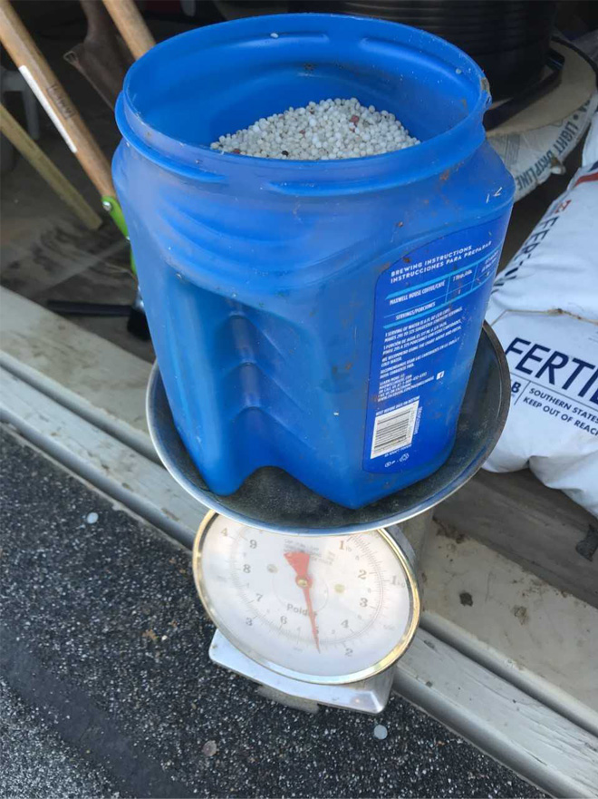 Bucket of fertilizer on a scale reading 5 lbs