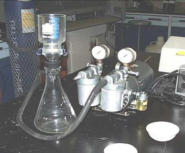 An Erlenmeyer flask is connected to a pump and other equipment for use in determining total suspended solids.