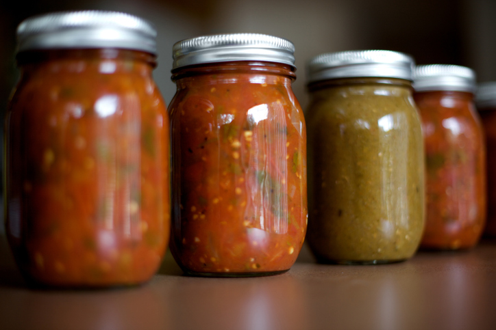 a row of jars of acidified foods on a shelf