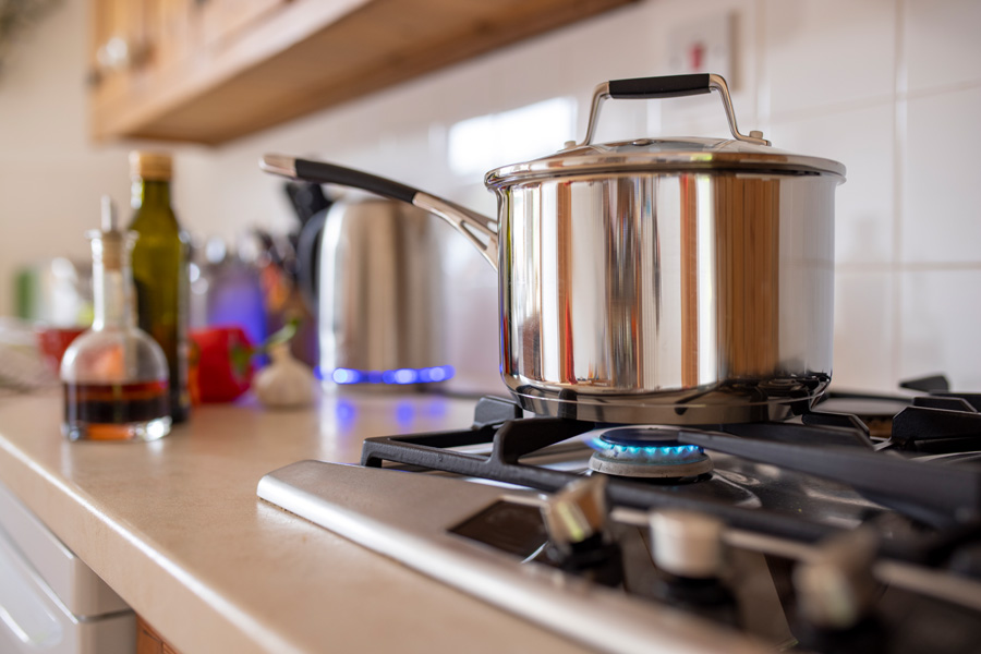 Gas stove with pot on the eye and blue flame