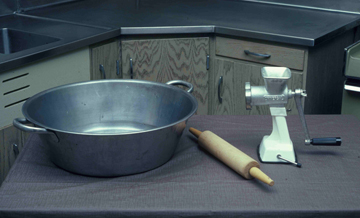 Metal tin, rolling pin, and food grinder on a counter
