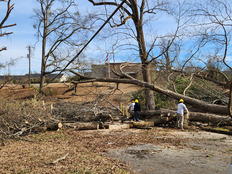 Community volunteers help remove fallen trees from roads in downtown Griffin.