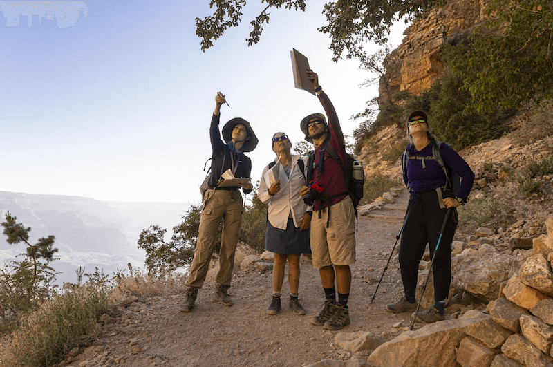 Students Hailey Bos (left) and Guy Kemelmakher (center right) discuss a geological feature with instructors Debra Dooley (center left) and Carolyn Cummings (right) while hiking the Grand Canyon’s Bright Angel Trail.