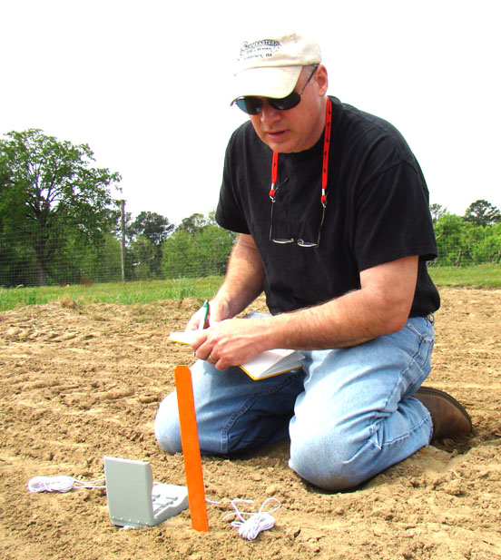 University of Georgia peanut agronomist John Beasley examines soil temperature at one of his field plots.
