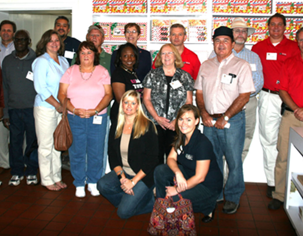 Members of this week's pre-conference farm tour pose for a picture on Tuesday at the Claxton Fruit Cake Factory.