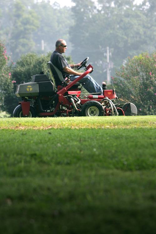 James Worley maintains turfgrass with a mower at the UGA College of Agricultural and Environmental Sciences in Griffin, Ga., July 26, 2005.