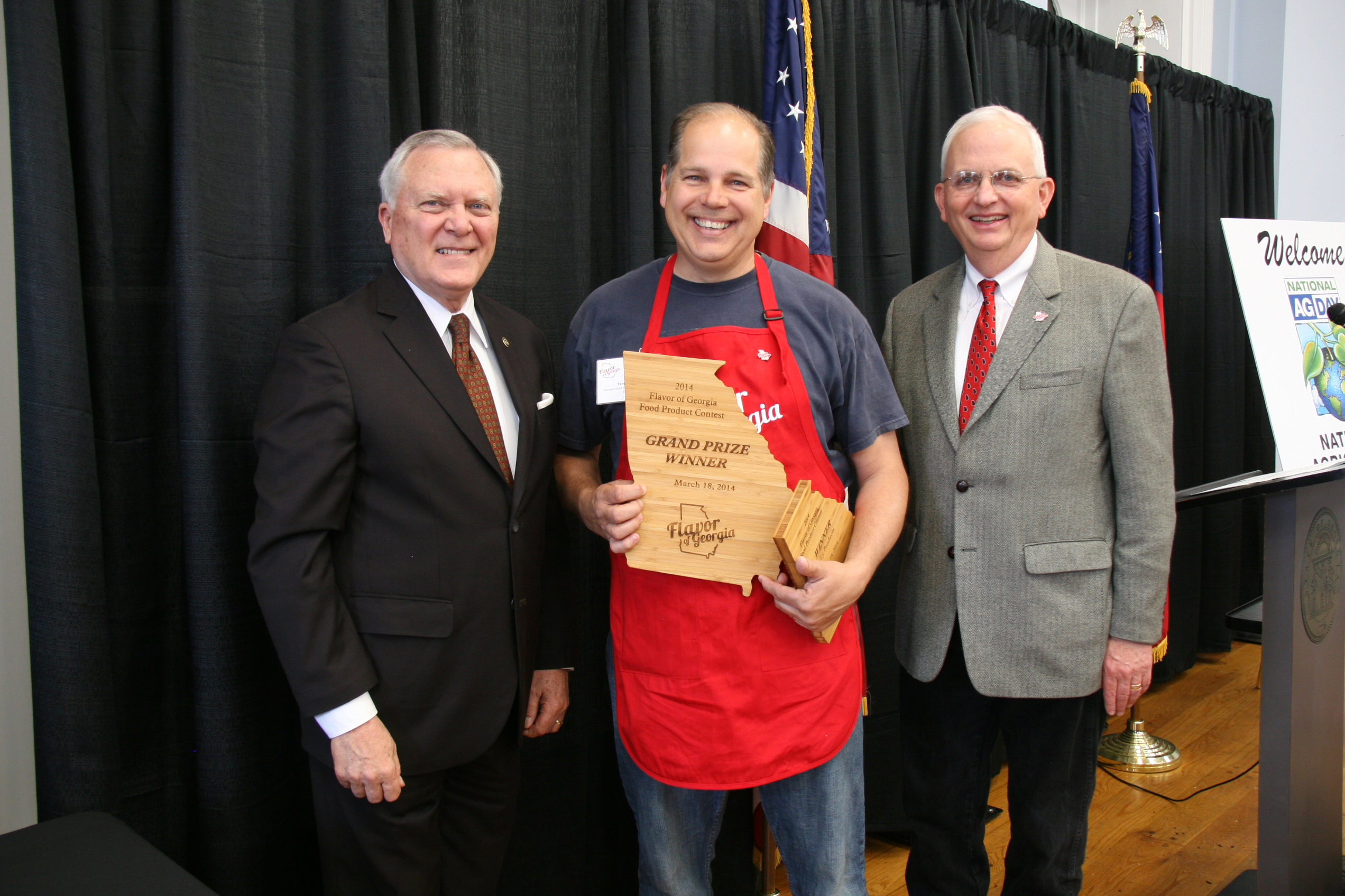 Tim Young, center, receives the Flavor of Georgia grand prize for his Georgia Gold Clothbound Cheddar from Gov. Nathan Deal and Agriculture Commissioner Gary Black on March 18.