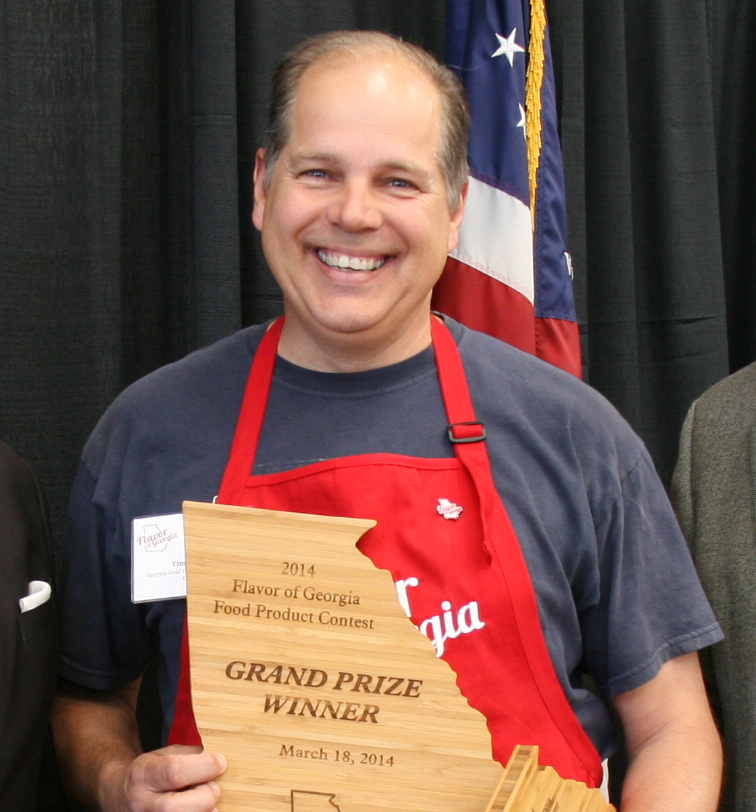 Tim Young, center, receives the Flavor of Georgia grand prize for his Georgia Gold Clothbound Cheddar from Gov. Nathan Deal and Agriculture Commissioner Gary Black on March 18.
