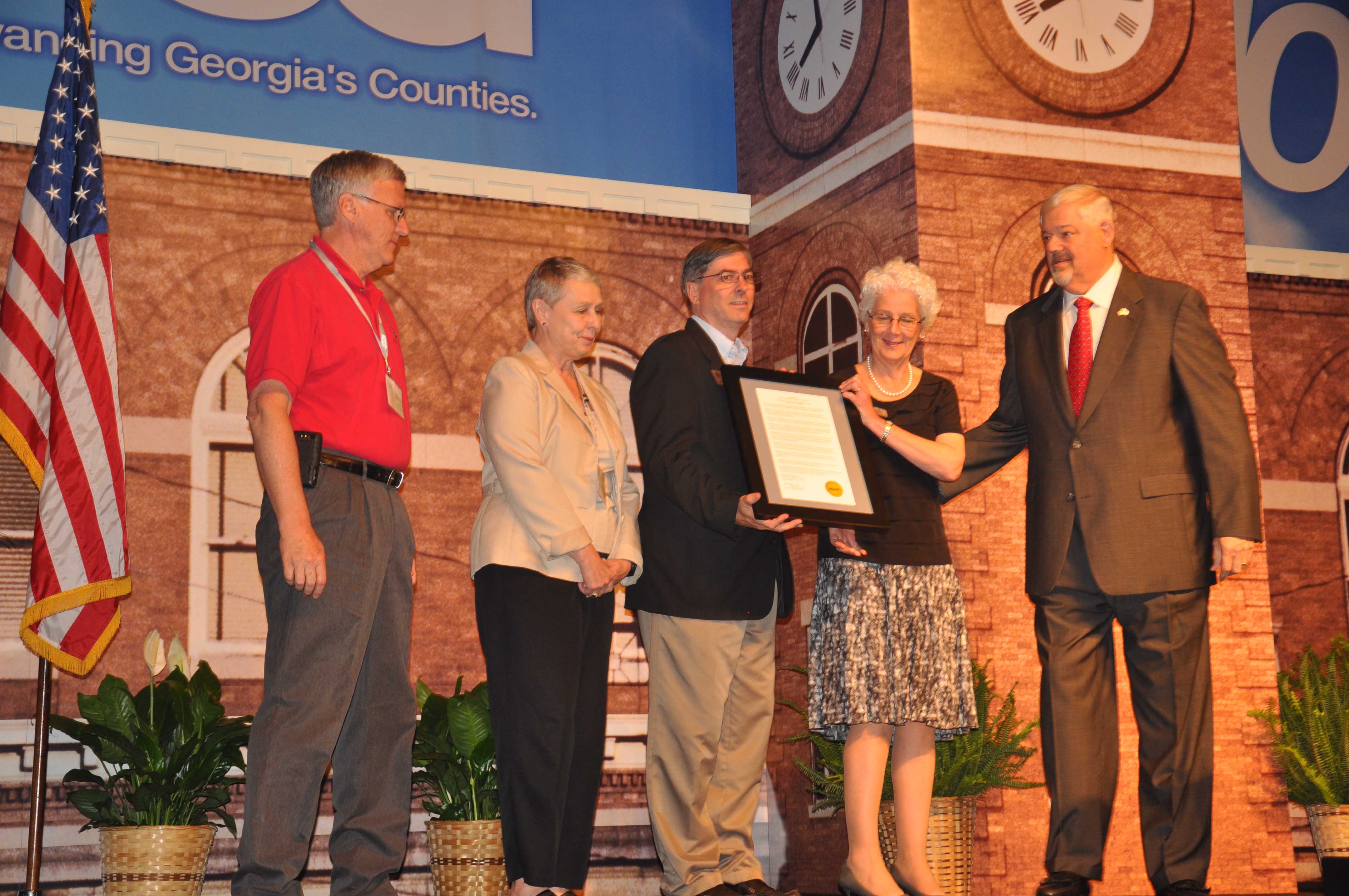 Associate Dean for Extension for the UGA College of Agricultural and Environmental Sciences Beverly Sparks accepts a proclamation recognizing the Georgia Association of Agricultural Agents from Mike Berg, outgoing president of the Association County Commissioners of Georgia.