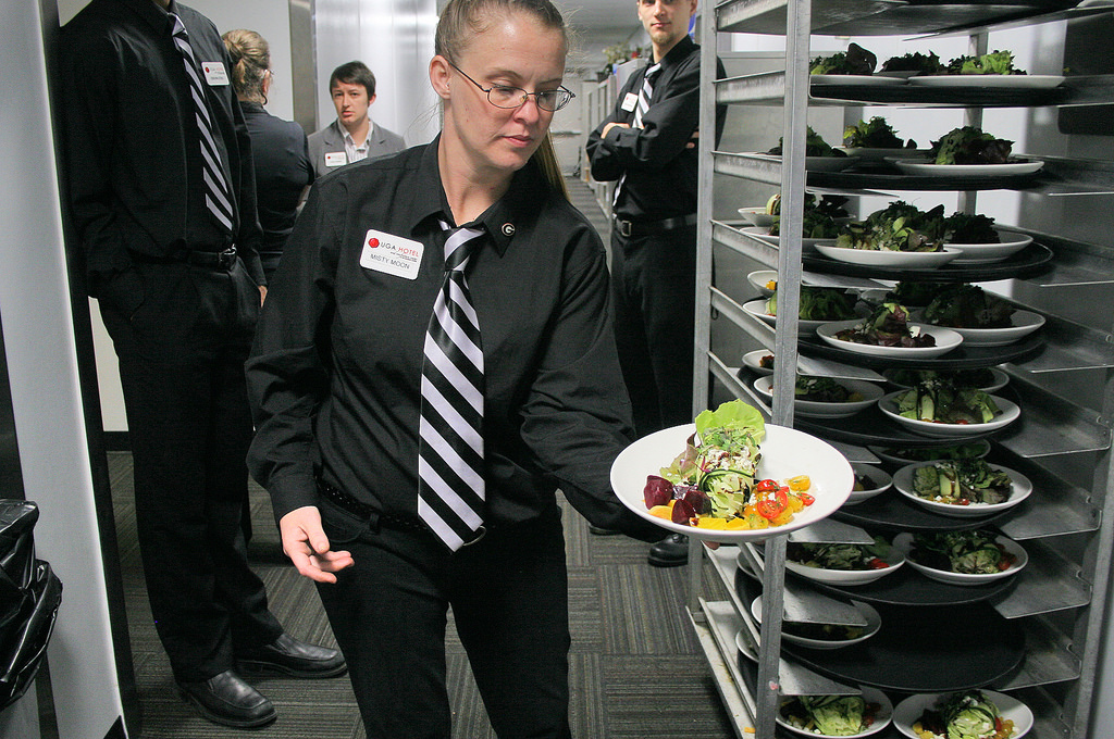 UGA Georgia Center server Mary Moon shows off a bouquet of salad greens grown by students in the UGA organic certificate program and prepared by Georgia Center chef Rob Harrison.