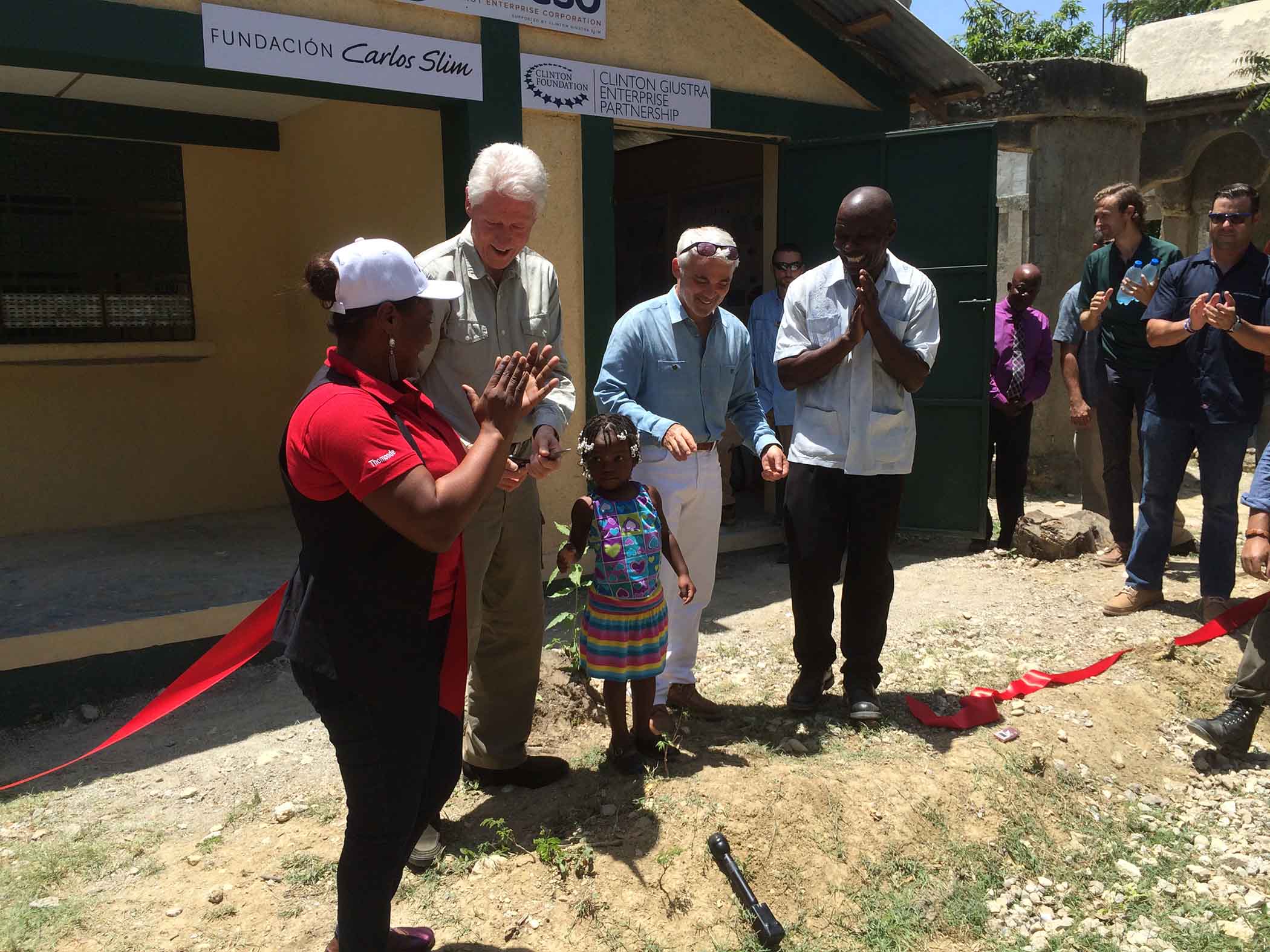 Former U.S. President Bill Clinton gathers with a group of townspeople from Tierra Muscady, Haiti, where he and philanthropist Frank Giustra launched the new Acceso Peanut Enterprise Corp., which is designed to improve the livelihoods of more than 12,000 smallholder peanut farmers.
