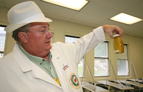 Putnam County Extension Coordinator Keith Fielder inspects a jar of honey. A Georgia Master Beekeeper, Fielder will lead a basic beekeeping class Aug. 7 in Madison.