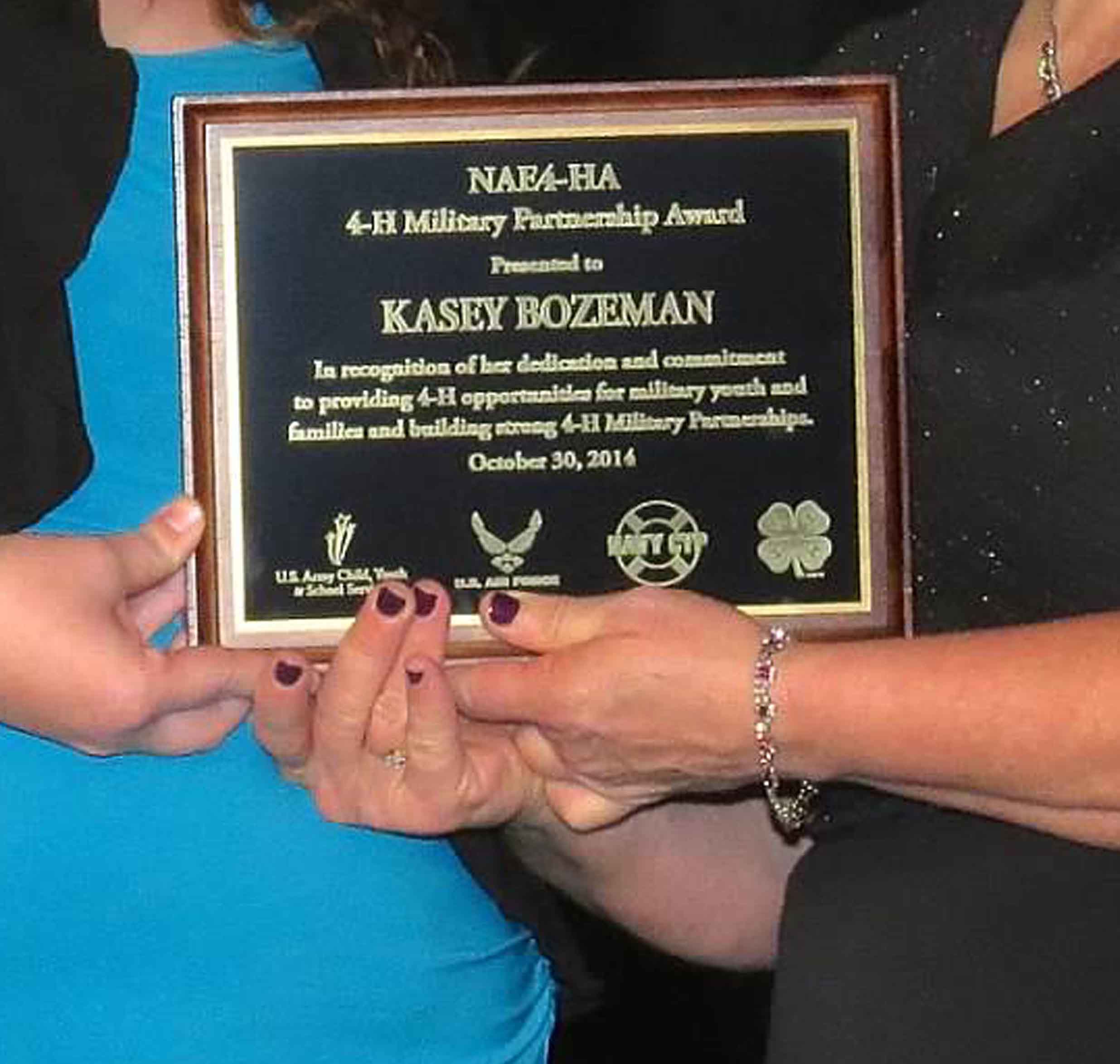 Pam Van Horn, president of the National Association of Extension 4-H congratulates Kasey Bozeman on receiving the association's 4-H Military Partnerships Award.