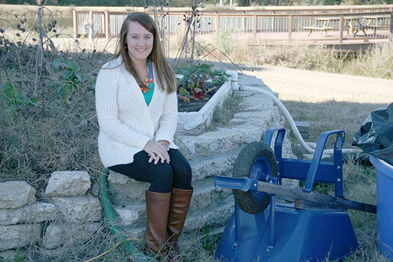 Amanda Miller sits next to her aquaponics system located behind the Future Farmstead on the UGA Tifton Campus.