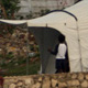 A tent encampment stands in Port-au-Prince, Haiti, March 16 beneath a crumbling building damaged by an earthquake Jan. 12 that killed an estimated 200,000 people and displaced many more.