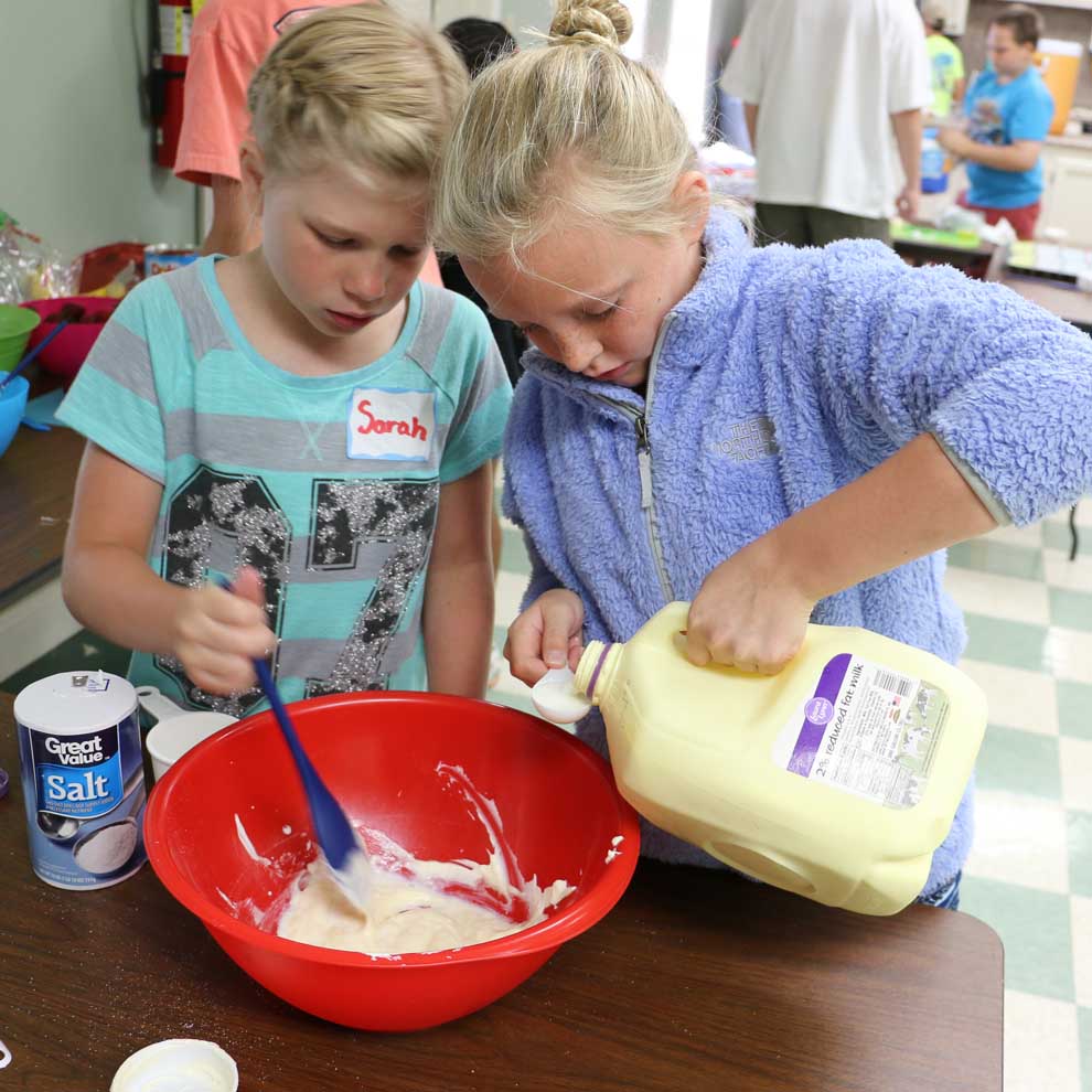 Sarah Bishop and Cailyn Berisko, Morgan County 4-H'ers, collaborate on a dressing for pasta salad during a Kids Can Cook camp this summer.