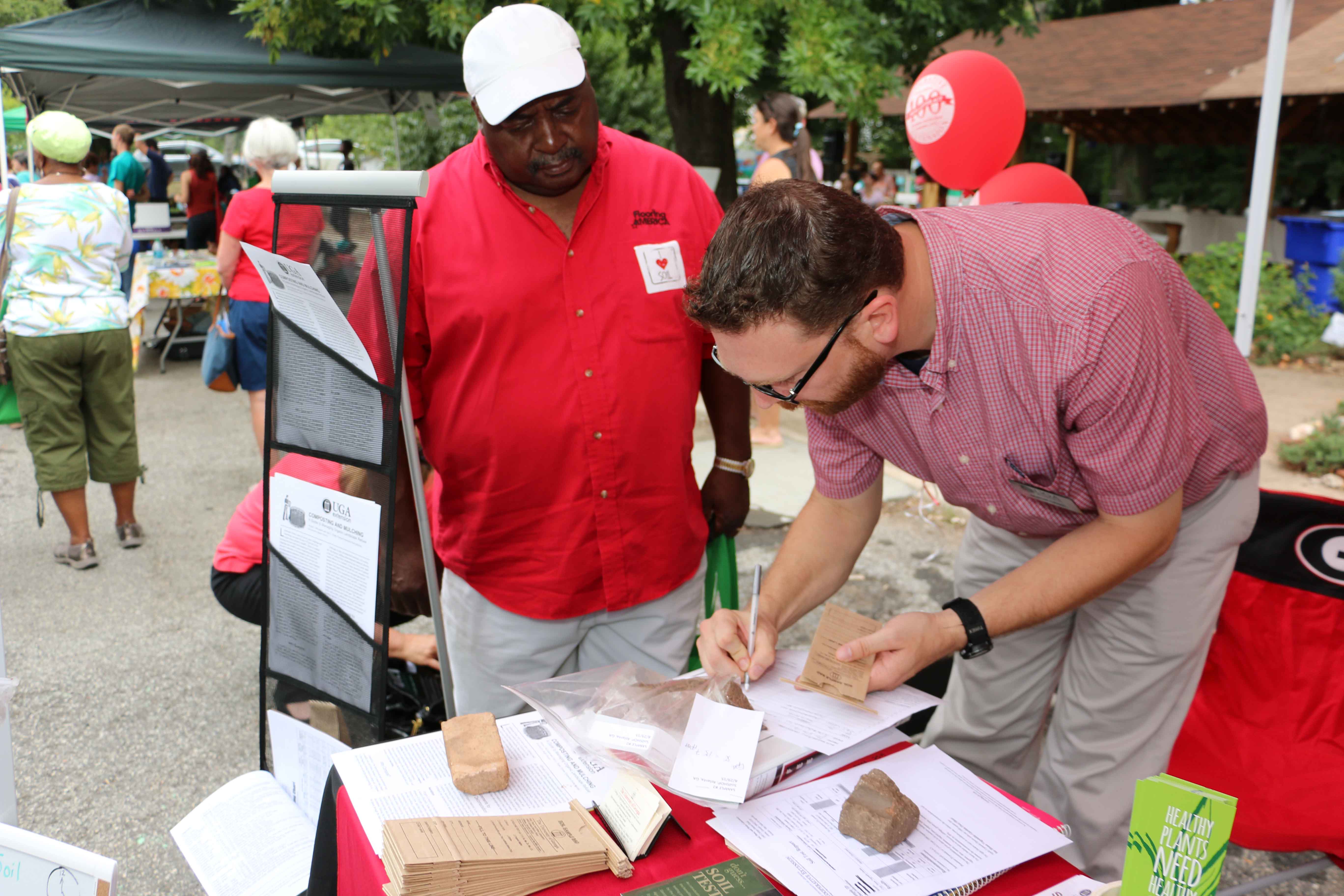 Calvin Sims, a community gardener from Lithonia, delivers a soil sample to UGA soil scientist Jason Lessl at the Healthy Soil, Healthy Community festival.