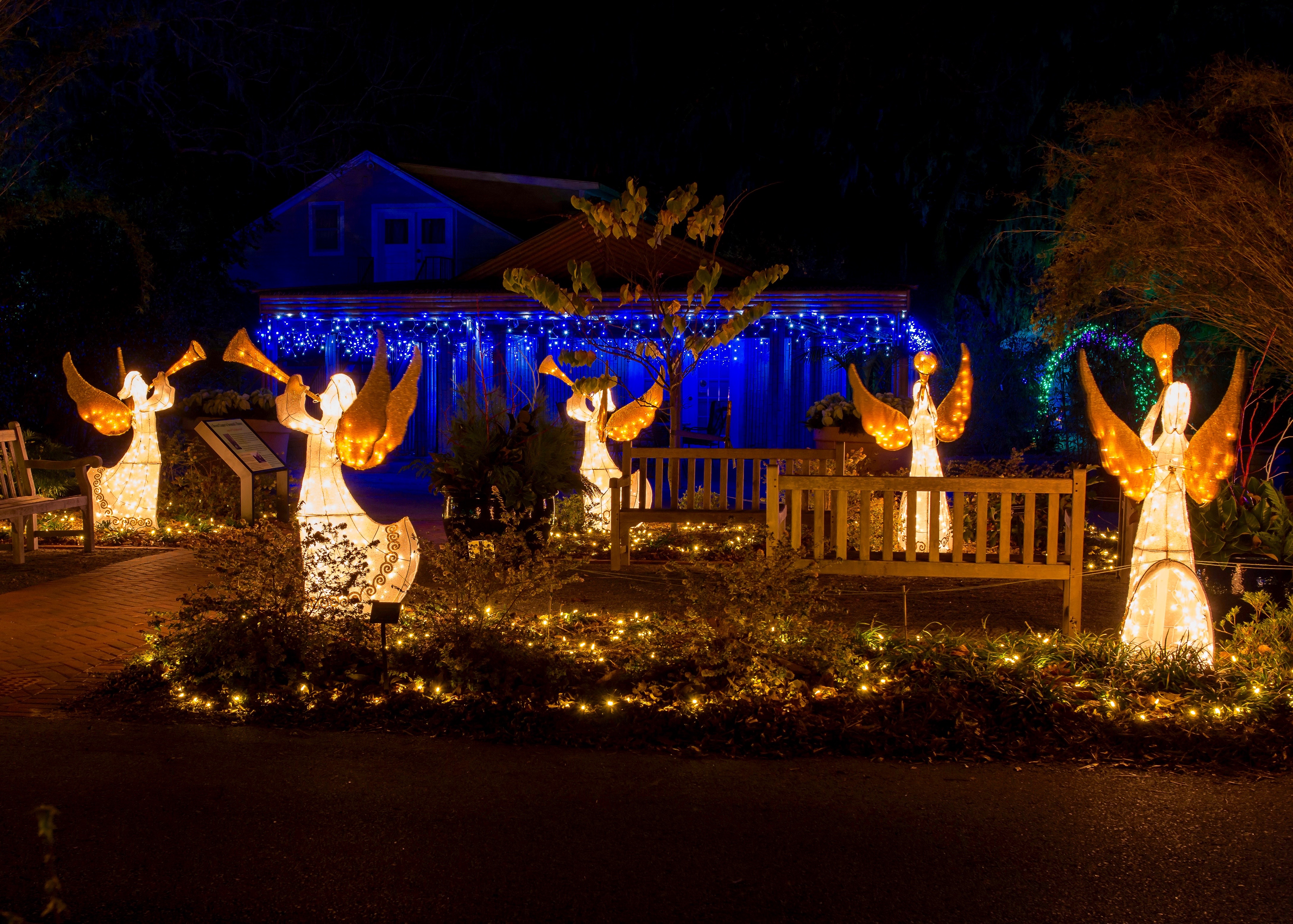 A holiday lights display with lit-up angels in the foreground and blue icicles in the background