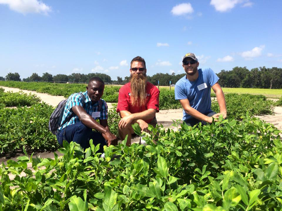 Abraham Fulmer (center) visits a U.S. peanut field with Haitian agronomist Jean Phillipe Dorzin (left) and Will Sheard of Meds & Food for Kids (right), in 2015.