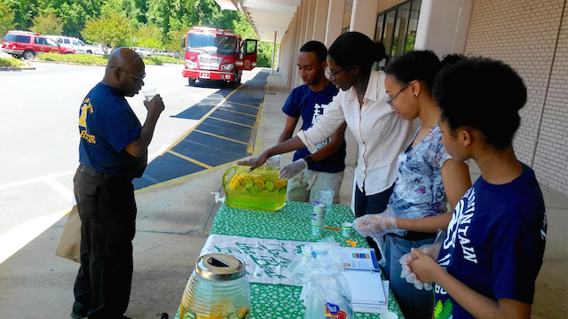 Decals County 4-H Club members Artis Trice, Nia Morrison, Chante' Lively and Claudia Thompson serve fruit infused water during the record-breaking first week of the DeKalb Mobile Market's 2016 season.