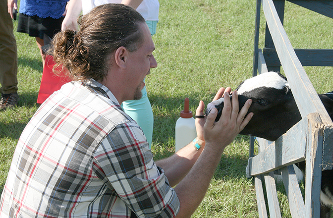 Alexander Bucksch talks with a cow during the New Faculty Tour on Thursday, August 4, at the UGA Tifton Campus.