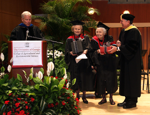Dr. Josef Broder, right, presents the Medallion of Honor to Minnie Foster, center left, and her sister Celestia Loden while Dr. J. Scott Angle explains the award. Broder is the associate dean of academic affairs at the UGA College of Agricultural and Environmental Sciences. Angle is the college's dean and director.