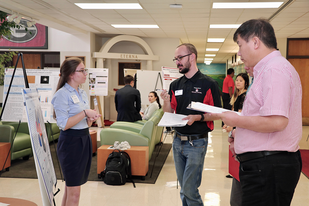 Jacy Donaldson, a senior studying biological science at the UGA College of Agricultural and Environmental Sciences, answers CAES faculty's questions about her research into the impact of medical costs on food insecurity at the CAES Undergraduate Research Symposium on April 12.