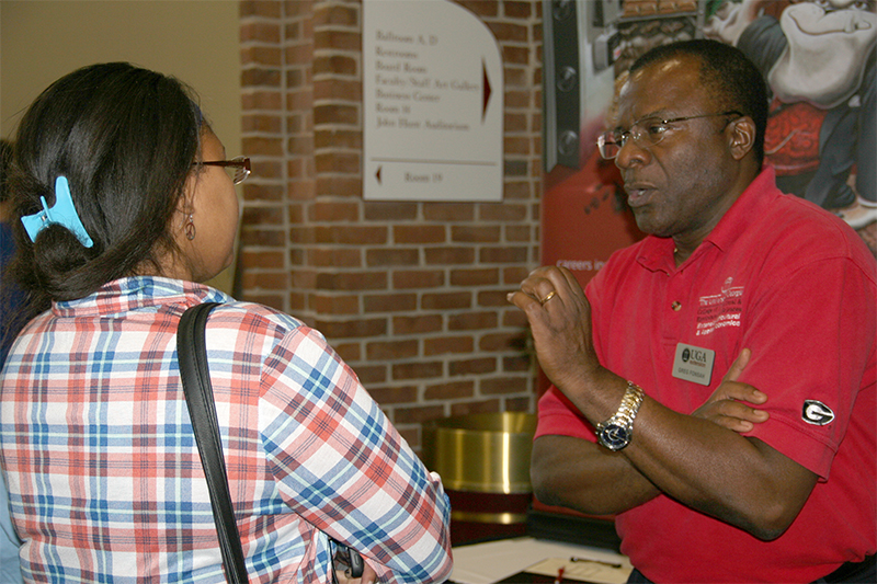 UGA-Tifton professor Greg Fonsah talks to a student during UGA ShowCAES in 2016.