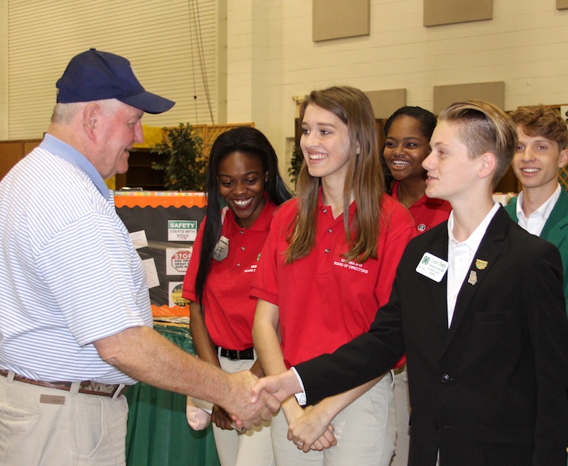 Secretary of Agriculture Sonny Perdue met with a group of select Georgia 4-H'ers on Friday, Oct. 6, in recognition of National 4-H Week, held Oct. 2-6. Perdue is shown being greeted by Pulaski County 4-H member Cooper Hardy. The secretary and the students toured the 4-H exhibits at the Georgia National Fair in Perry, Georgia, the former Georgia governor's hometown. He also heard presentations from three Georgia 4-H'ers: Amelia Day of Houston County, Angel Austin of Ben Hill County and Evie Woodward of Coffee County.