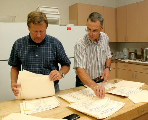 UGA Cooperative Extension coordinators Forrest Connelly (Stephens County), left, and Bob Waldorf (Banks County) sort certificates before handing them out to Master Goat Farmer participates.