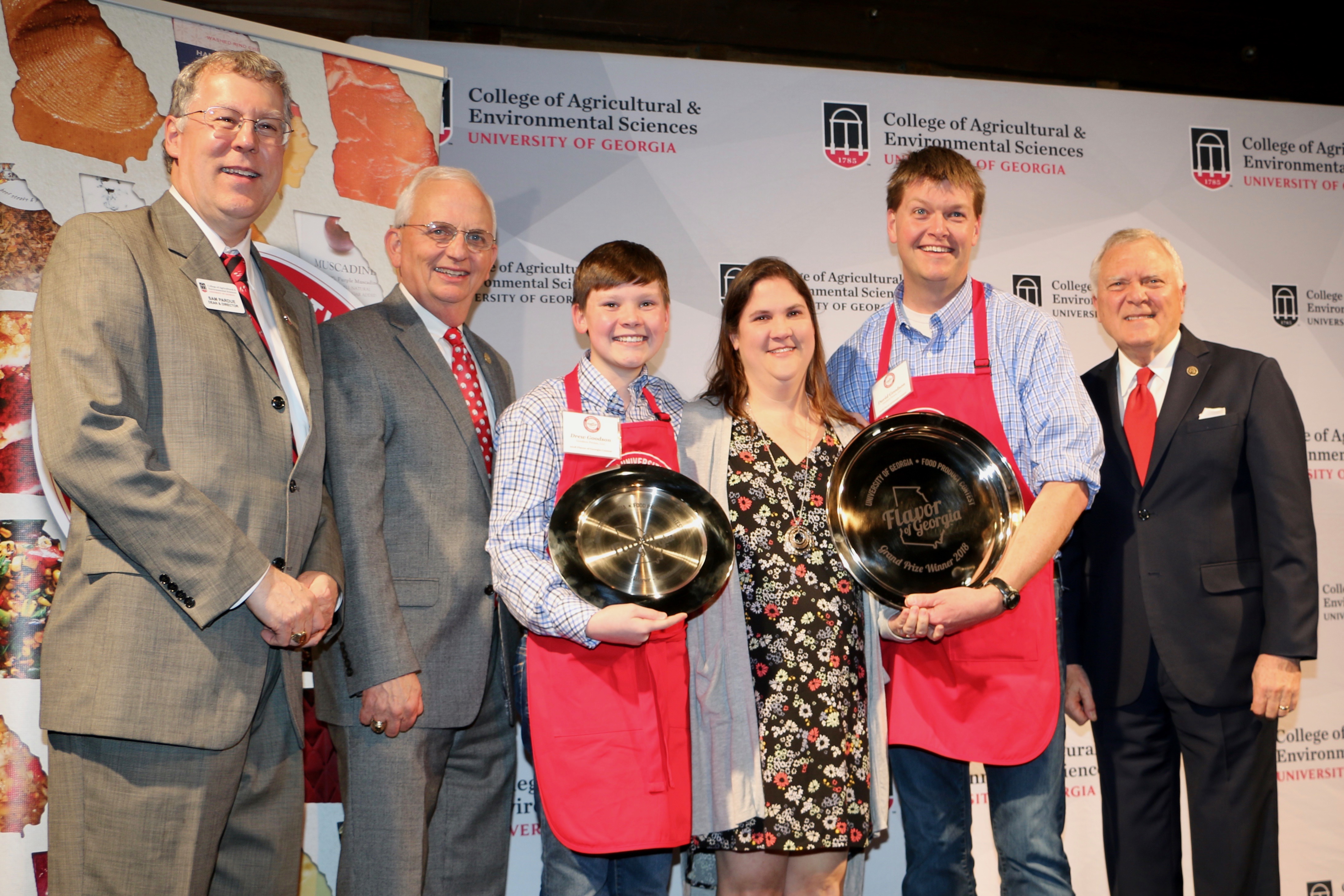 UGA College of Agricultural and Environmental Sciences Dean and Director Sam Pardue and Georgia Commissioner of Agriculture Gary Black congratulate Drew, Melody and David Goodson with Governor Nathan Deal after they won the grand prize.