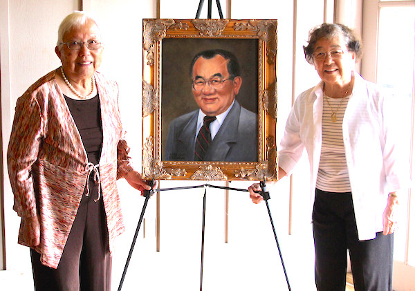 During a remembrance ceremony, a portrait of Tommy Nakayama, painted by Griffin, Georgia, artist Jennifer Edwards, was unveiled. Nakayama is a former head of the UGA Department of Food Science and Technology. His portrait will hang in the UGA Center for Food Safety on the university's Griffin campus alongside images of food science department heads who preceded Nakayama. A 'Thunderhead' Japanese black pine tree was also planted in the garden in honor of Nakayama and his heritage. Nakayama's wife (L) and sister are shown unveiling the portrait.