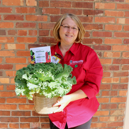 Kim Fritz, agricultural and natural resources program assistant for UGA Cooperative Extension in Gwinnett County shows off one of the centerpieces created by Gwinnett County Farm to School students for the 2018 Golden Radish awards.