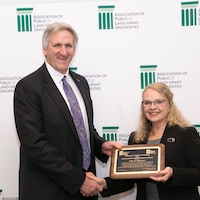 John Buckwalter, Chair of the Board on Human Sciences of the Association of Public and Land-Grant Universities presents 
Professor Judy Harrison, of the UGA College of Family and Consumer Sciences Department of Foods and Nutrition with the 2018 Outstanding Engagement Award.